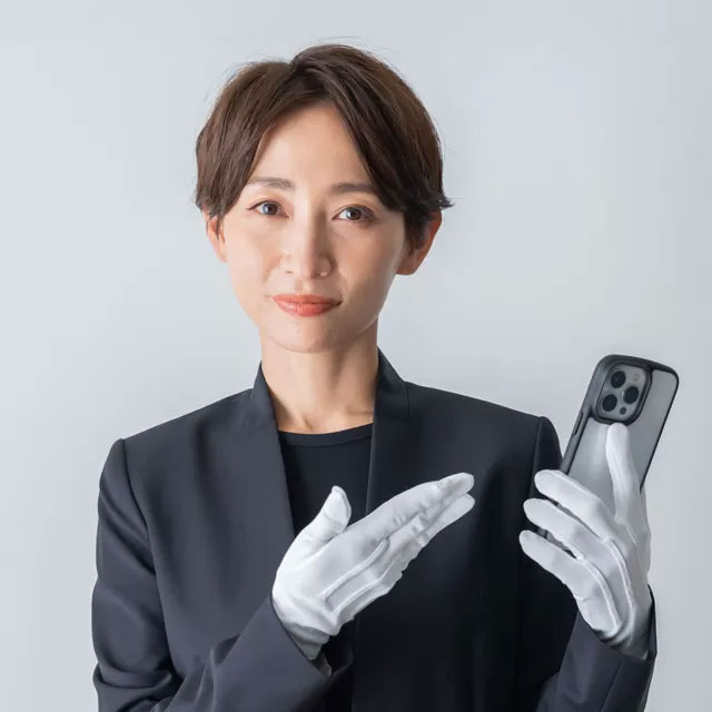白石葬祭の女性スタッフが白手袋でスマホを示し野田市での葬儀搬送を案内している