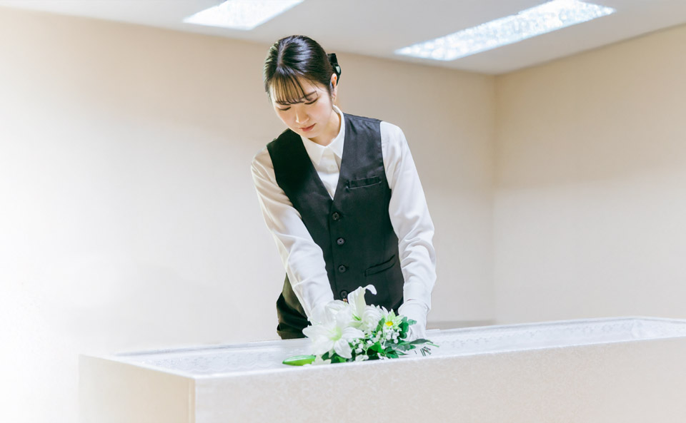 白石葬祭が野田市で寝台車搬送後に白い花を棺に整える葬儀準備スタッフ