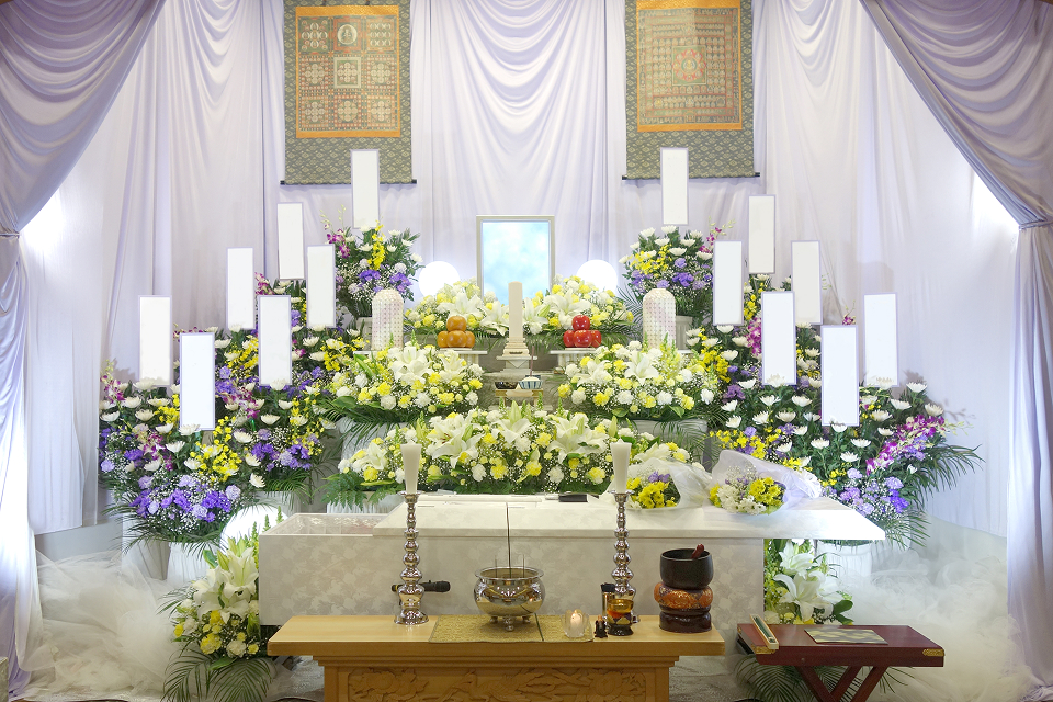 白石葬祭が野田市で施行する白基調の祭壇に黄色白の花を配した一般葬の式場風景、葬儀 野田市